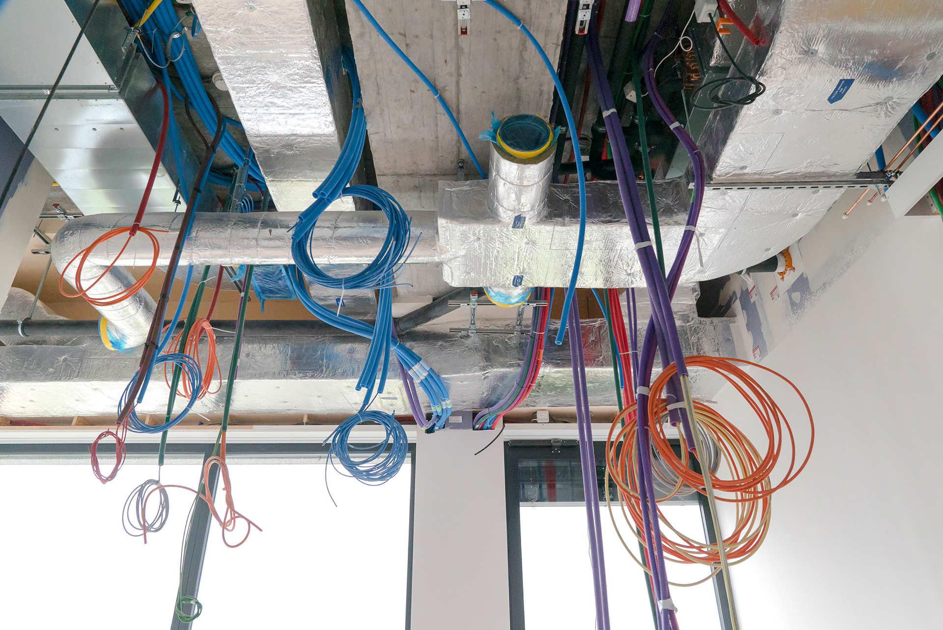colorful electrical cables hanging from the ceiling in spirals a